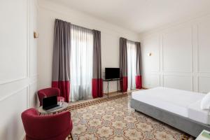 een hotelkamer met een bed en twee stoelen bij SJR Luxury Apartment Trevi Fountain in Rome