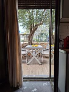 einen Tisch und Stühle auf einer Terrasse mit einem Baum in der Unterkunft Aelia Suites in Áyios Pétros