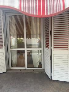 einer Glastür eines Gebäudes mit einer roten Markise in der Unterkunft La Terrazza in San Giovanni Valdarno