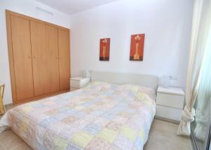 1 dormitorio con 1 cama y armario de madera en RNET - Apartment Roses Les Marines GREGAL en Roses