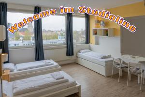 a room with two beds and a table and a window at Trendy Apartments in Berlin