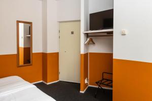 een kamer met een bed, een televisie en een deur bij Cosy Hotel in Historical Center of Blokzijl in Blokzijl