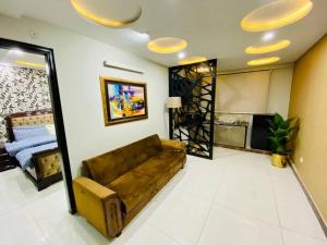 ein Wohnzimmer mit einem braunen Sofa in einem Zimmer in der Unterkunft 103-NEXT INN Tailored to your Highest Standards in Lahore