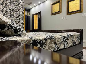 ein Schlafzimmer mit einem Bett mit einer schwarzen und weißen Decke in der Unterkunft 103-NEXT INN Tailored to your Highest Standards in Lahore