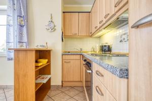 a kitchen with wooden cabinets and a counter top at Parkresidenz am Hafen Wohnung HF 14 in Zingst