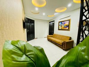 ein Wohnzimmer mit einem Sofa in einem Zimmer in der Unterkunft 103-NEXT INN Tailored to your Highest Standards in Lahore
