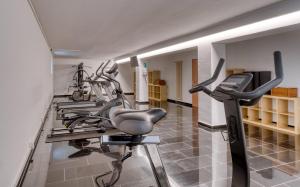 um ginásio com várias bicicletas de exercício numa sala em MaxAparthotel by homekeepers em Fürth