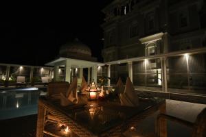 patio nocturno con mesa y chimenea en The Tiger Villa by ATD India - Group of Hotels and Resorts, en Sawāi Mādhopur