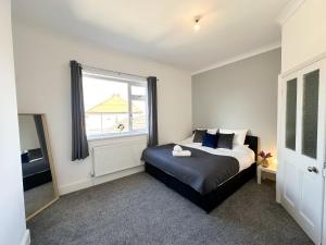 a bedroom with a bed and a large window at Wrightson House by Blue Skies Stays in Stockton-on-Tees