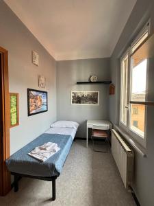 a bedroom with a bed and a table and a window at Glitter Home in La Spezia