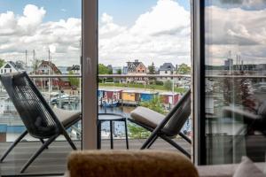 twee stoelen op een balkon met uitzicht op een jachthaven bij 4Hafenzeiten - Ferienwohnung NIE 11 Hamburg in Timmendorfer Strand