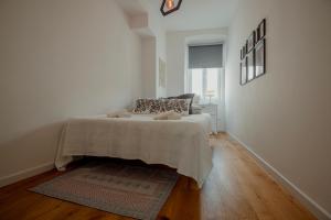 um quarto branco com uma cama e uma janela em Elegant Apartment 28 San Giacomo em Trieste