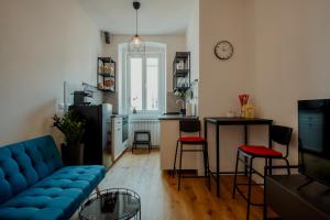 uma sala de estar com um sofá azul e uma cozinha em Elegant Apartment 28 San Giacomo em Trieste