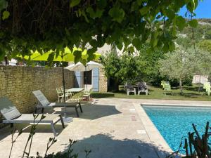 a patio with a table and chairs and a pool at Chambres d'hôtes "LA NESQUE" in Venasque