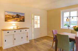 a kitchen and dining room with a table and chairs at Jöri Hüs 1 in Nebel
