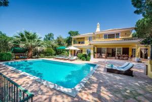 una piscina frente a una casa en Villa Plaza - beautiful spacious house off roundabout 6 Quinta Do Lago en Quinta do Lago