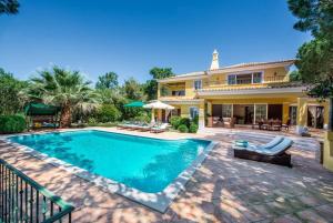 una piscina davanti a una casa di Villa Plaza - beautiful spacious house off roundabout 6 Quinta Do Lago a Quinta do Lago