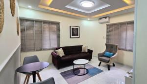 a living room with a couch and a table and chairs at The Leneade in Abuja