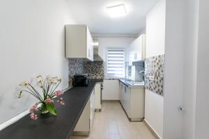 a kitchen with white cabinets and a black counter top at Emma's Green Home in Râşnov