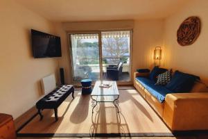 sala de estar con sofá azul y mesa en T3 Plage du Golf Piscine WIFI - ROSSIconciergerie - Linge inclus, en La Grande-Motte