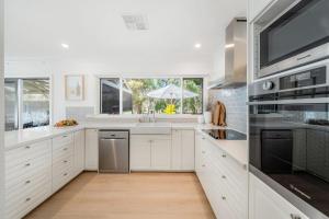 a kitchen with white cabinets and a large window at The Grape Escape Location and style on Shiraz Trail in McLaren Vale