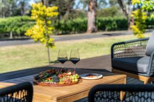 a tray of food and two glasses of wine on a table at The Grape Escape Location and style on Shiraz Trail in McLaren Vale