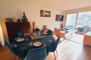 sala de estar con mesa y sillas azules en T3 Plage du Golf Piscine WIFI - ROSSIconciergerie - Linge inclus, en La Grande-Motte
