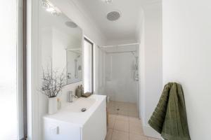 a white bathroom with a sink and a shower at The Grape Escape Location and style on Shiraz Trail in McLaren Vale