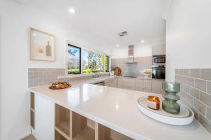 a white kitchen with a large white counter top at The Grape Escape Location and style on Shiraz Trail in McLaren Vale