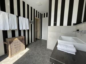 ein Bad mit einer schwarz-weißen gestreiften Wand in der Unterkunft 4Hafenzeiten - Ferienwohnung NIE 9 Lotte in Timmendorfer Strand