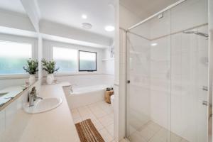 a white bathroom with a shower and a sink at The Grape Escape Location and style on Shiraz Trail in McLaren Vale