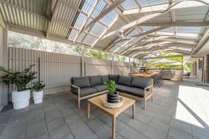 a conservatory with a couch and tables on a patio at The Grape Escape Location and style on Shiraz Trail in McLaren Vale