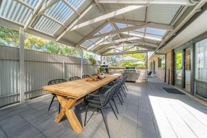 an outdoor patio with a wooden table and chairs at The Grape Escape Location and style on Shiraz Trail in McLaren Vale