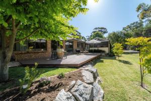 a backyard with a wooden deck and a house at The Grape Escape Location and style on Shiraz Trail in McLaren Vale
