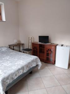 1 dormitorio con cama, escritorio y nevera en Casa Bianca, en Sant'Egidio del Monte Albino