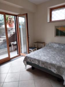 1 dormitorio con 1 cama y puerta corredera de cristal en Casa Bianca, en Sant'Egidio del Monte Albino