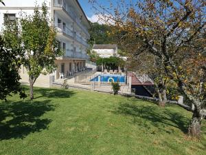 a yard with a swimming pool in front of a building at APARTAMENTOS CANADA 2 in Raxó