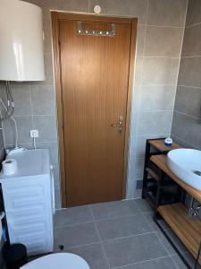 a bathroom with a toilet and a wooden door at Apartment Privlaka direkt am Strand mit Klima und neuem Badezimmer Haustiere sind willkommen in Privlaka +36 photos