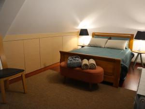 een slaapkamer met een bed met een stoel en 2 lampen bij Casal dos Frades in Fontainhas
