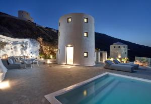 a villa with a swimming pool at night at Topos Exclusive in Imerovigli