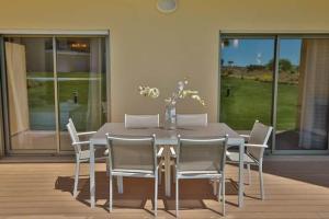 uma mesa de jantar e cadeiras numa casa em Marina Jardim - Great complex for families em Albufeira