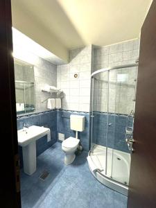 a bathroom with a toilet and a shower and a sink at Hotel Yaky Center in Piteşti