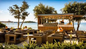 a restaurant with tables and chairs next to the water at Maistra Camping Amarin Pitches in Rovinj +29 photos