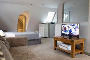 uma sala de estar com uma cama e uma televisão de ecrã plano em KingsHouse In Cheam Village em Cheam