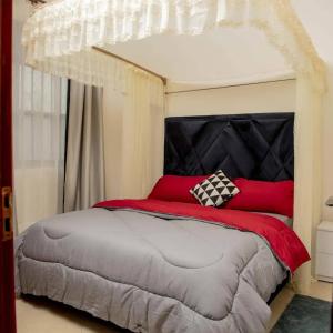 Lovana apartments and hotel في غولو: غرفة نوم بسرير كبير ومخدات حمراء