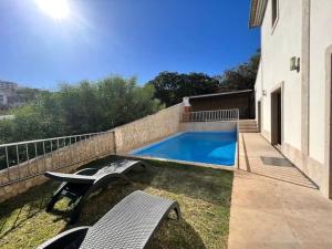 una piscina con panchina accanto a un edificio di Villa Pedra Luxe - Spacious modern villa ad Albufeira