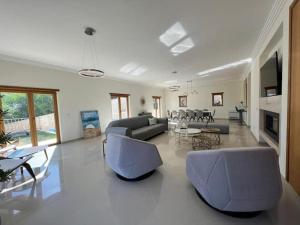 un soggiorno con divano, sedie e tavolo di Villa Pedra Luxe - Spacious modern villa ad Albufeira