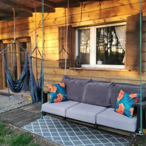 eine Couch auf der Veranda eines Hauses in der Unterkunft Dream Forest Cabin in Warschau