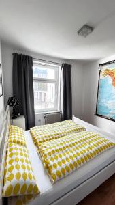 - une chambre dotée d'un lit avec des draps jaunes et blancs dans l'établissement Nord Ost Apartment, à Kiel