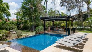 a pool with lounge chairs and a pergola at Casa de Campo 4-BR Retreat: Pool, Jacuzzi, Sauna, Chef & Maid in La Romana